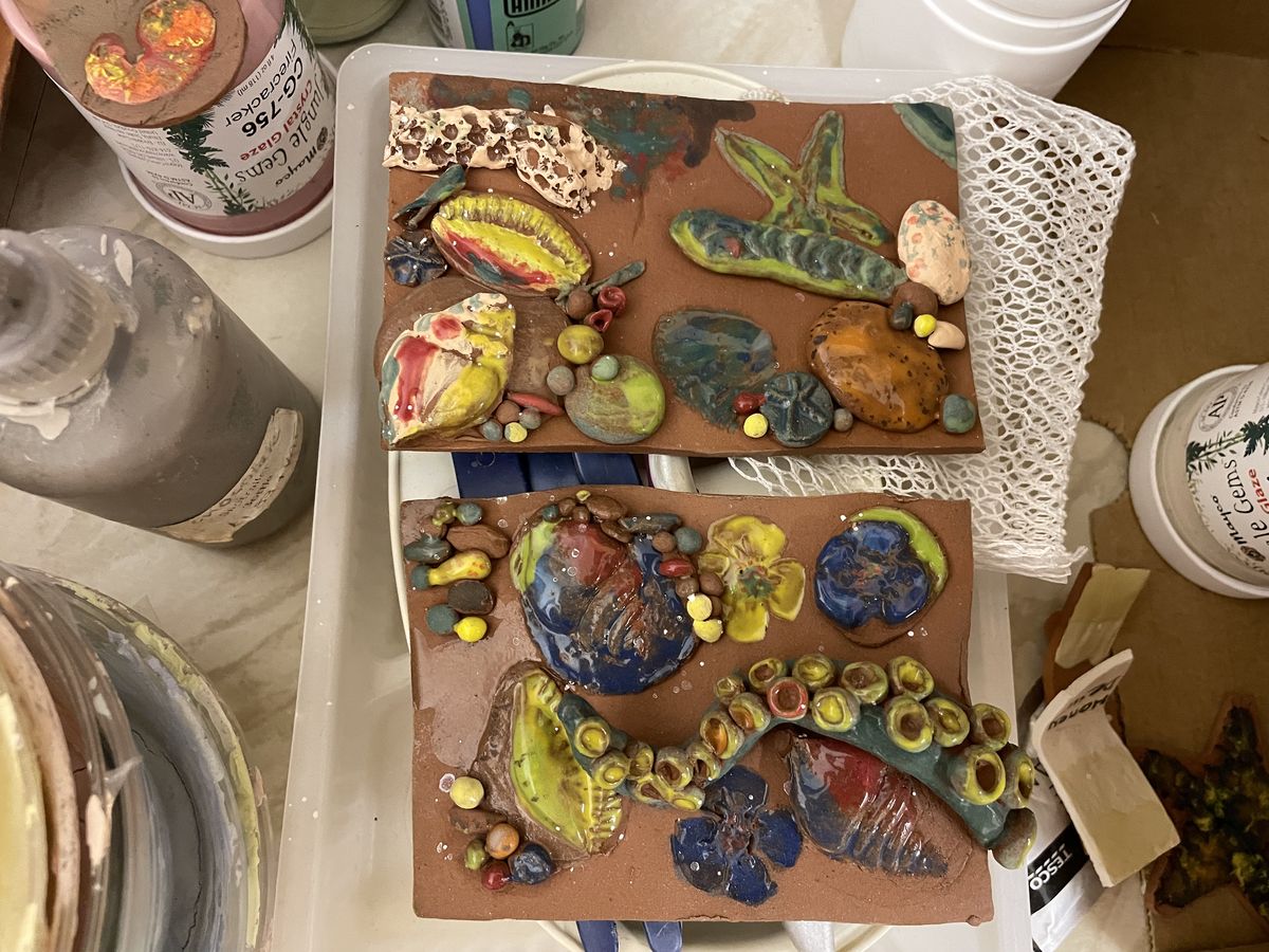 Ceramic relief panel painted with caterpillars and butterflies