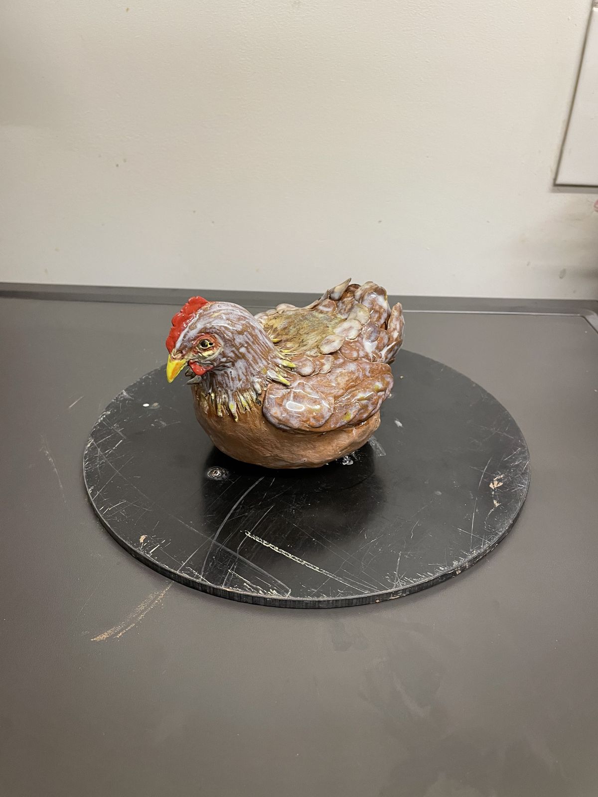 Speckled brown ceramic hen with a red comb